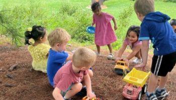Preschoolers playing with trucks outside