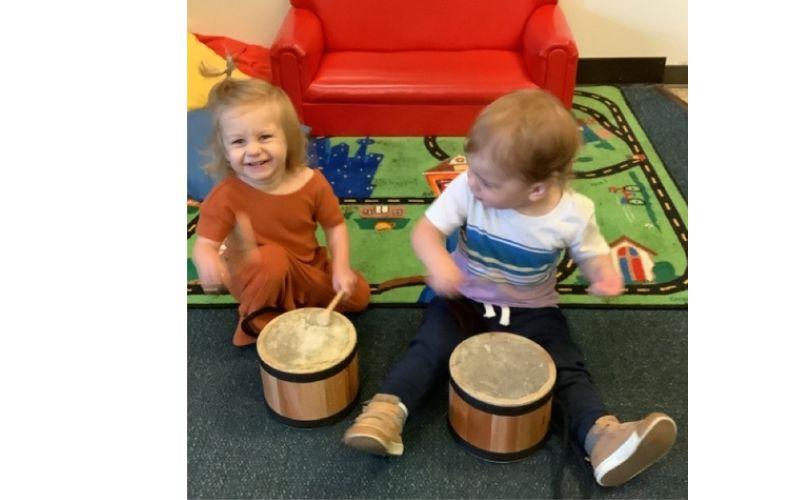 2 toddlers playing drums at preschool