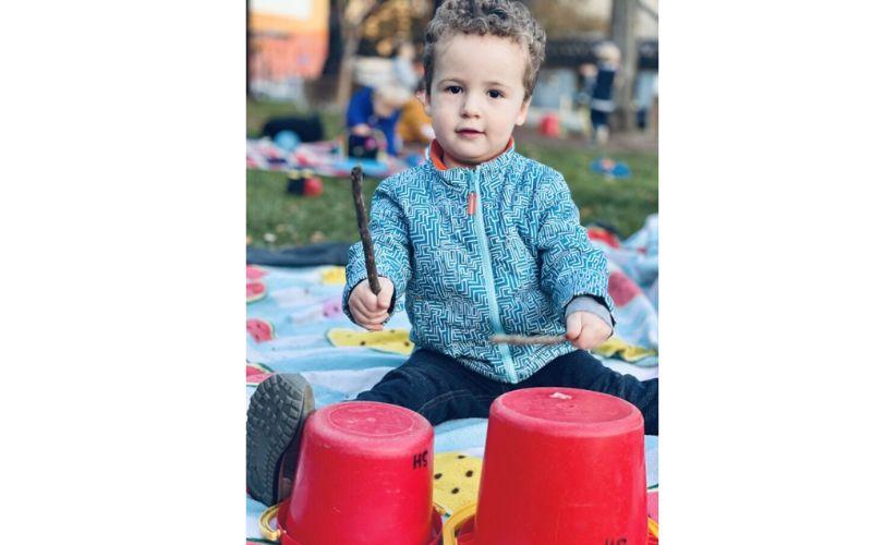 Preschooler playing buckets like drums
