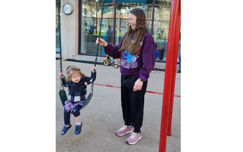 Teacher pushing child on a swing