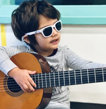 Boy in sunglasses playing guitar
