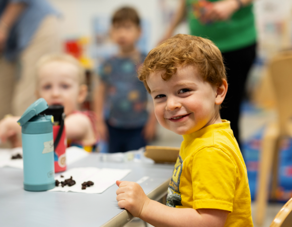 Smiling preschooler at lunch table