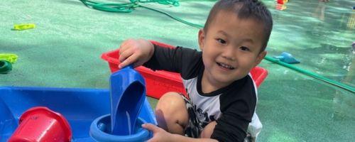 Preschooler playing with water toys